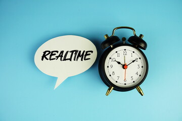 Realtime text on speech bubble with alarm clock on blue background