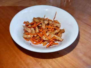 Spicy oriental salad with soy asparagus and carrot in a white bowl. Healthy nutritious for restaurant menu or cooking blog.