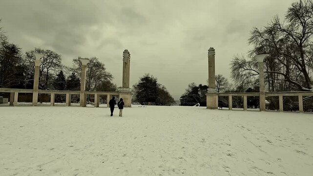 Handheld video of the Propylaea, the central entrance of Varna Sea Garden, covered in snow. Designed by architect Georgi Ovcharov in 1939, with a snowy VARNA sign and walking silhouettes, BG, 2026