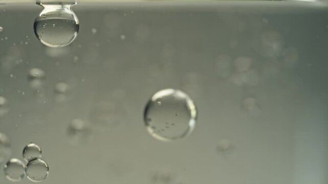 4K cinematic video, slow-motion kombucha SCOBY moving clear liquid, tiny bubbles rising, swirling patterns, macro translucent textures ambient light, ethereal reflections dreamy scientific organic