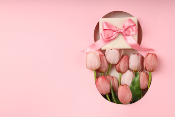 Obraz premium Pink tulips and a gift are perfect for Women's Day celebration