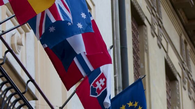 National Flags Waving from Ornate Historic Building Facade in Prague