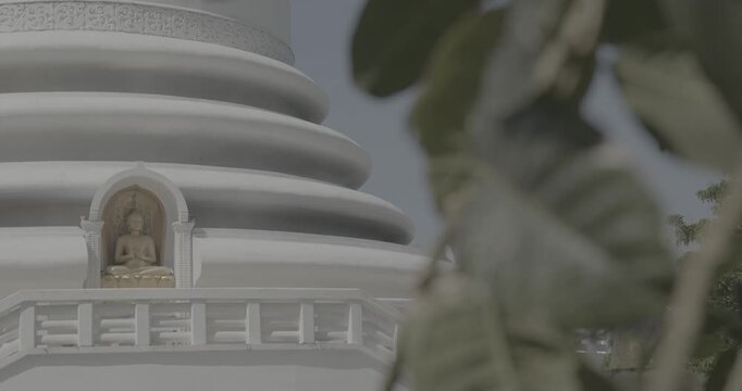 Japanese Peace Temple In Rumassala, Galle, Sri Lanka. Close up Famous landmark and cultural sacred place. The golden statue of Lord Buddha in Parinirvana, Japanese Peace Pagoda. View of the Japanese