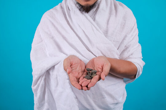 Muslim Pligrim in White Ihram Holding Small Stones for Jamarat
