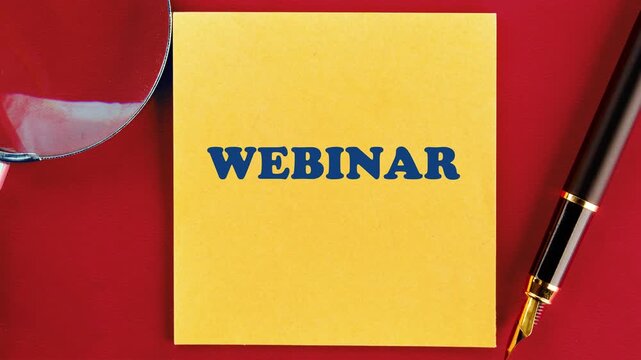 The word Webinar gradually becomes clear on a yellow sticky note placed on a vibrant red surface