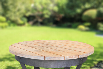 Obraz premium Empty round wood table top with abstract blur park garden background