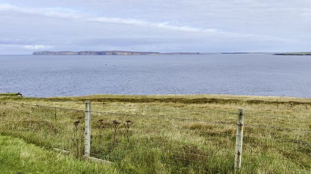 Holborn Head as viewed from a cliff walk in Scotland. Green grassy fields and beautiful skies.