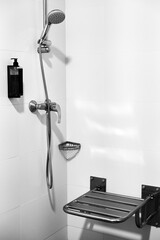 An example of a shower set for the elderly: a folding seat, a grab bar, a shower head on a stand,...