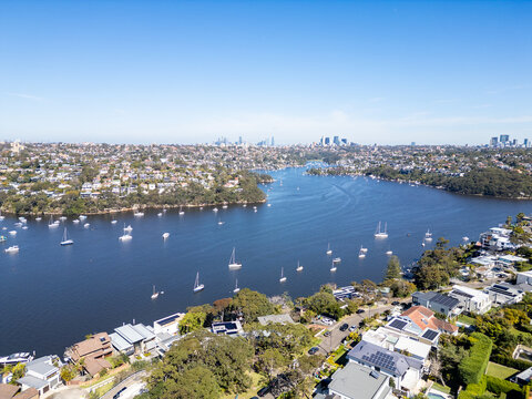 Sydney, Australia: Aerial view of yachts in Sydney bay in Australia. With forward motion showing the CBD skyline and the Mosman luruxy residential suburd on a sunny day