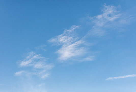 A clear blue sky with a few clouds