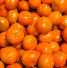 A pile of oranges are sitting on a table