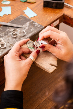 Close-up of Hands Using Tools to Chack Variscite Stone and Materials on a Wooden Table