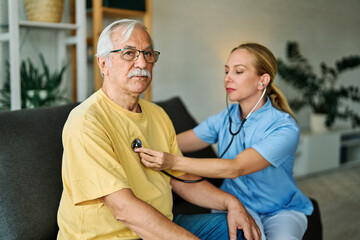 Doctor or nurse caregiver with senior man at home or nursing home