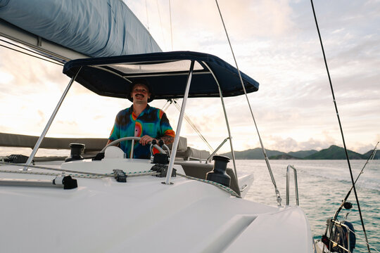 Skipper Standing at Helm on Catamaran during Ocean Voyage, Seych