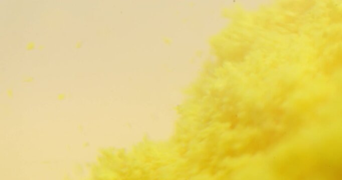 Macro shot of yellow effervescent tablet dissolving in water with particles dispersing