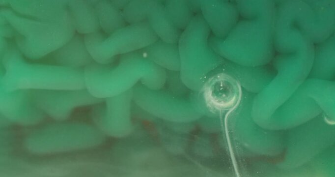 Macro Close-up of Emerald Green Rippling Liquid Texture with Air Bubble