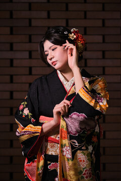 Woman in kimono with floral pattern at night for Seijin no Hi