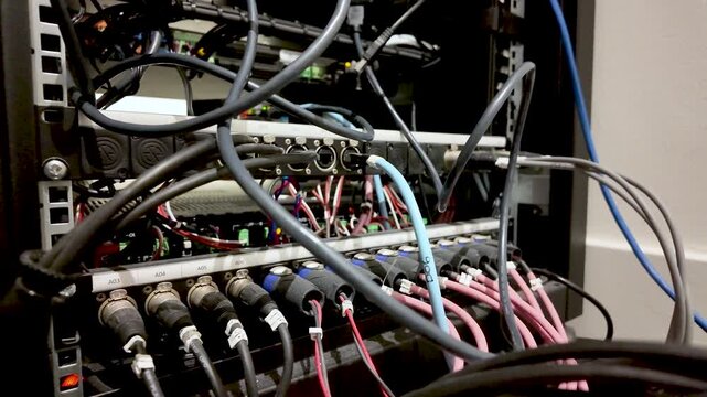 Audio visual rack with interconnected XLR cables and wiring, showing data and power connections