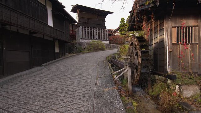 Old Edo era street side water wheel in Nakasendo town of Tsumago, Japan