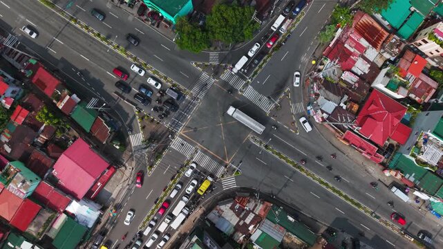 Top down drone orbiting Taguig intersection with traffic officers on sunny day