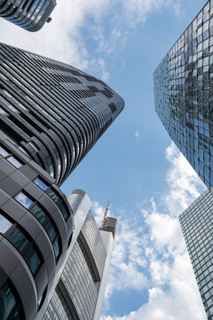 Curved skyscraper viewed upward in urban frankfurt germany with blue sky highlighting dynamic architecture and strong perspective lines in the city