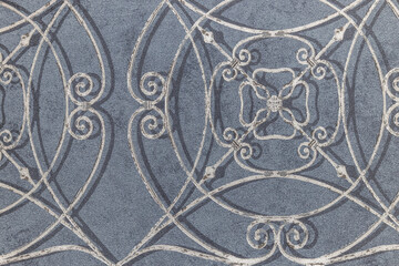 Ornate wrought iron pattern on blue wallcovering background