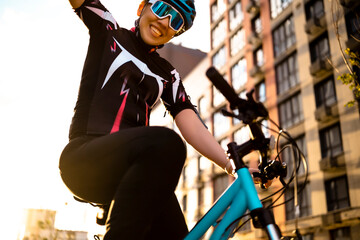 Close up portrait of smiling woman cyclist in helmet and sunglasses. Pure joy and positive emotions from sports and active hobby.