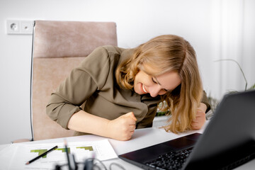 Triumphant woman celebrating victory with clenched fists sitting at office desk near laptop. Pure joy, emotional breakthrough, successful deal celebration, professional triumph excitement.