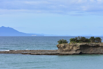 Eroded coastal cliffs and rock shelves stretching into ocean. Location: Omaha Bay Tawharanui Peninsula New Zealand
