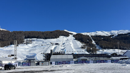 Obraz premium Livigno, Italy - February 1, 2026: Snow sports competition area and temporary infrastructure prepared for Milano Cortina 2026 Winter Olympics in Livigno