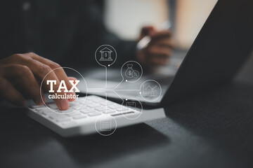 Using a tax calculator on a white calculator with laptop for financial calculations and tax planning