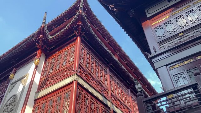 Traditional Chinese houses viewed from below. Upturned eaves, carved wooden latticework, vibrant colors, multi-tiered architecture, and complex structures.