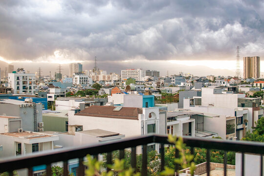 Vietnam Da Nang city view from balcony with railing and dark clouds at sunset