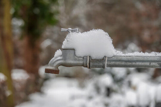 Wasserhahn draussen bedeckt mit Schnee