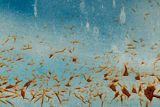 Blue metal surface with rusted paint flaking off