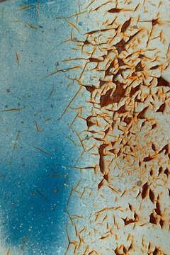 Deteriorating blue paint with rust showing through