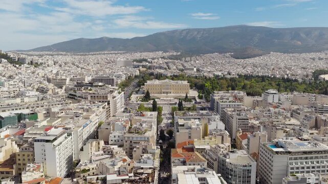 Cinematic drone shot approaching Syntagma Square from Ermou Street, with the Hellenic Parliament in the background