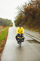 Fototapeta premium Mature man, cyclist and bicycle in woods for fitness, tourism exercise and minimalistic travel. Space, male person and cycling for bikepacking, workout safety and adventure activity in countryside