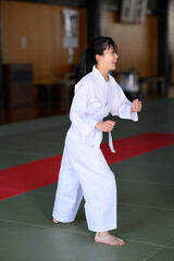道場でダイナミックなハイキックを決める空手着の小学生女子