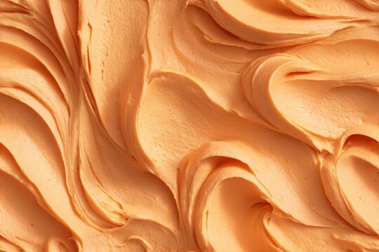 Orange cream frosting texture background. Sweet dessert food pattern. Close up view of butter icing for cake decoration.