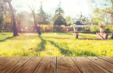 Obraz premium Wooden table and natural blurred background, picnic in sunny spring park