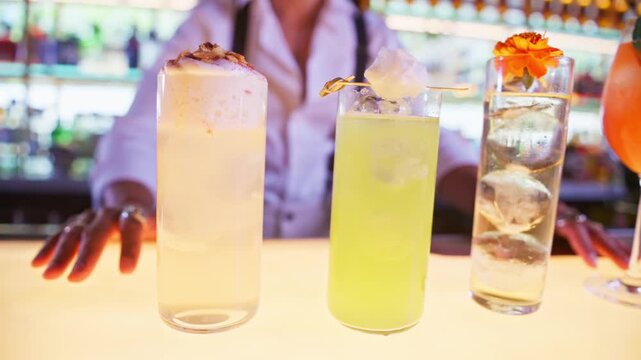 Bartender serving a row of colorful cocktails on bar counter