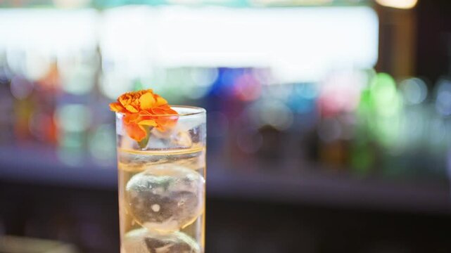 Bartender garnishing a pink monkey cocktail with orange flower