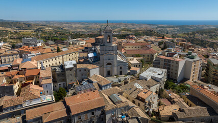 Obraz premium Aerial view of the Cathedral of Santa Maria Assunta, located in the city of Catanzaro, Calabria, Italy. It's located in the historic center of the town. On the horizon is the Ionian Sea and a blue sky