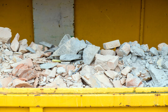 rubble is located in a yellow open industrial waste container