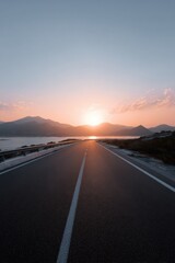 Fototapeta premium Sunset over open road with mountain views and clear sky