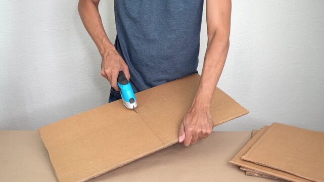 Cutting cardboard with electric cardboard cutter, arts establisher