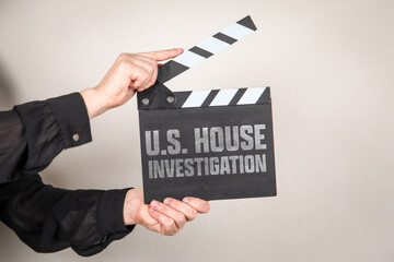 U.S. HOUSE INVESTIGATION Clapperboard Held By Hands Against Neutral Background