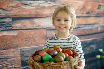 Fototapeta premium Sweet toddler child, cute boy playing with colorful easter eggs