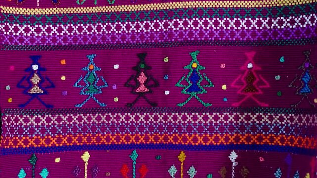 Traditional Guatemalan textile with colorful woven and embroidered figures